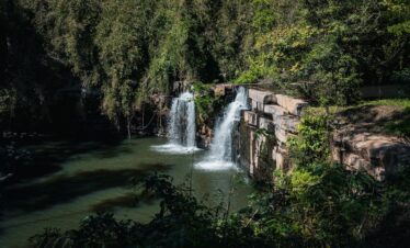 Serene waterfall cascading in the lush forests of Thailand, surrounded by vibrant greenery.