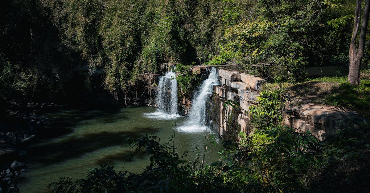 Serene waterfall cascading in the lush forests of Thailand, surrounded by vibrant greenery.
